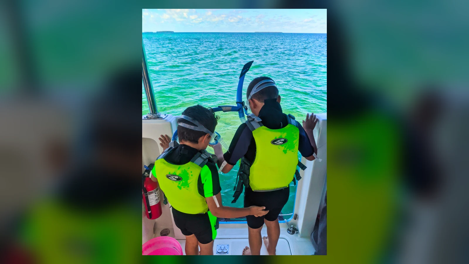 海を前にライフジャケットとシュノーケルを着ける子どもたちの後ろ姿