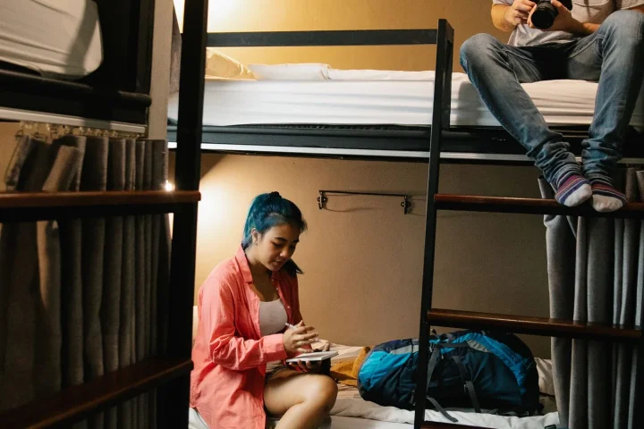 二段ベッドの相部屋で過ごす二人の旅行者