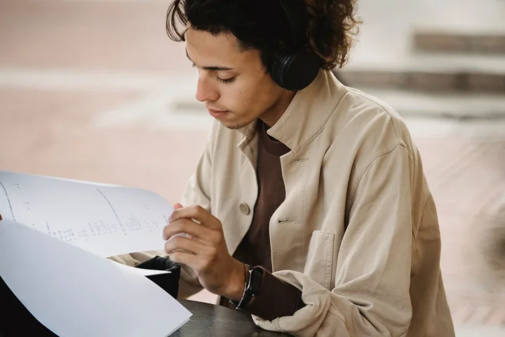 ヘッドホンで音声を聞きながら資料を確認する学生