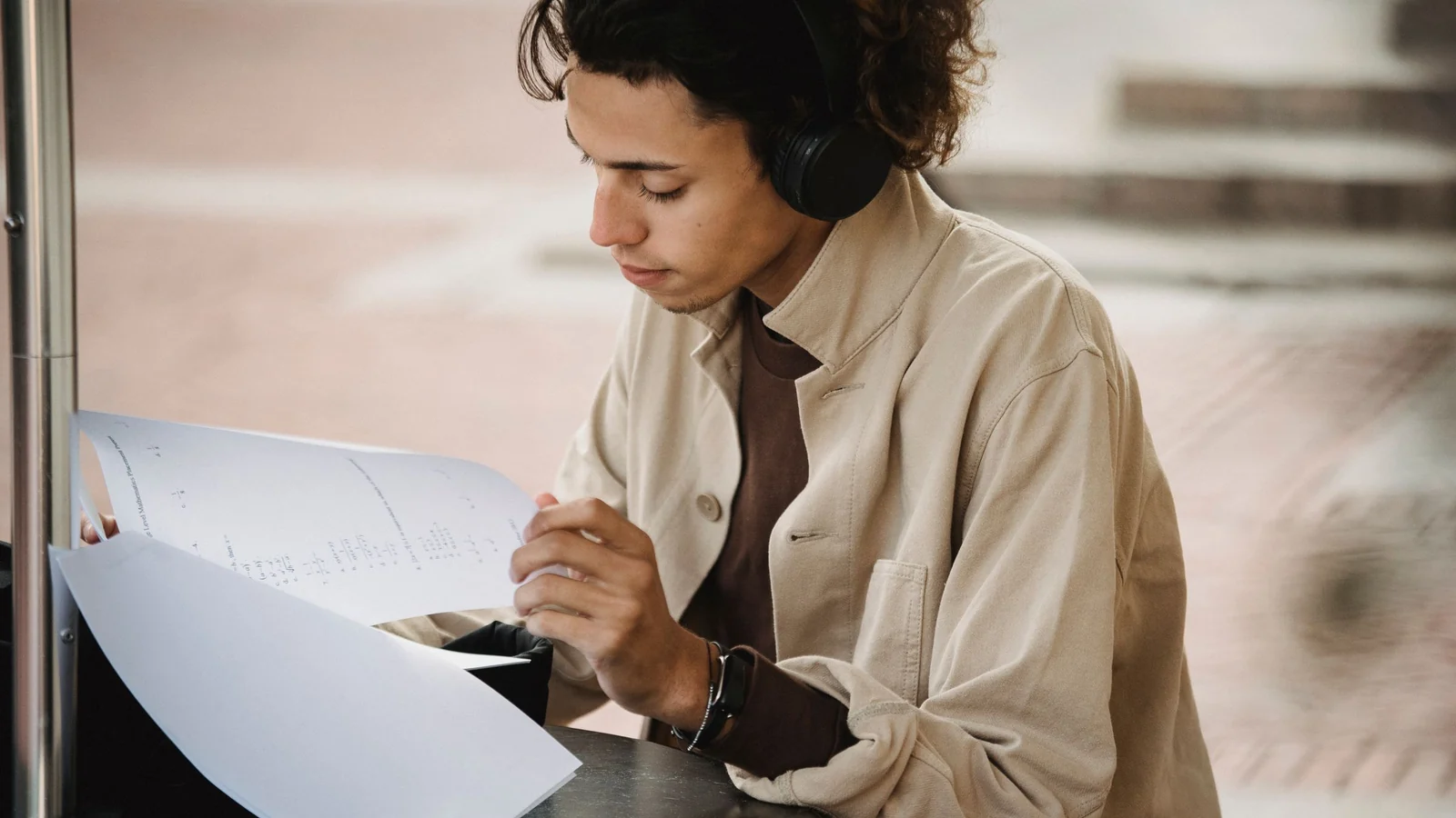 ヘッドホンで音声を聞きながら資料を確認する学生