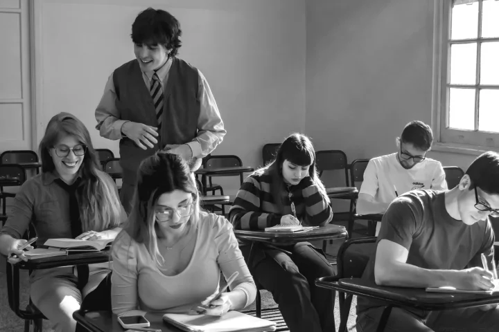 教室で課題に取り組む学生を見守る教師