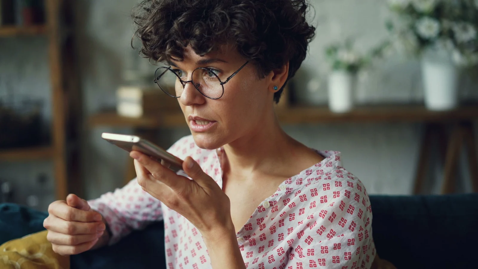 スマートフォンに向かって声を録音する女性