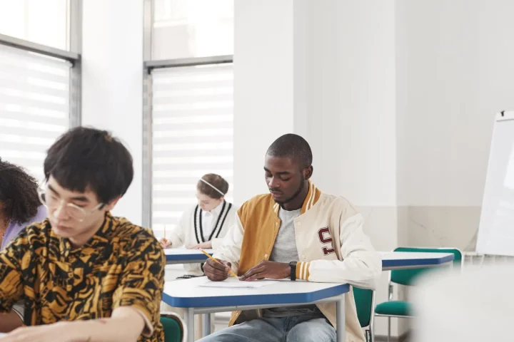 教室で英語力確認のテストを受ける学生