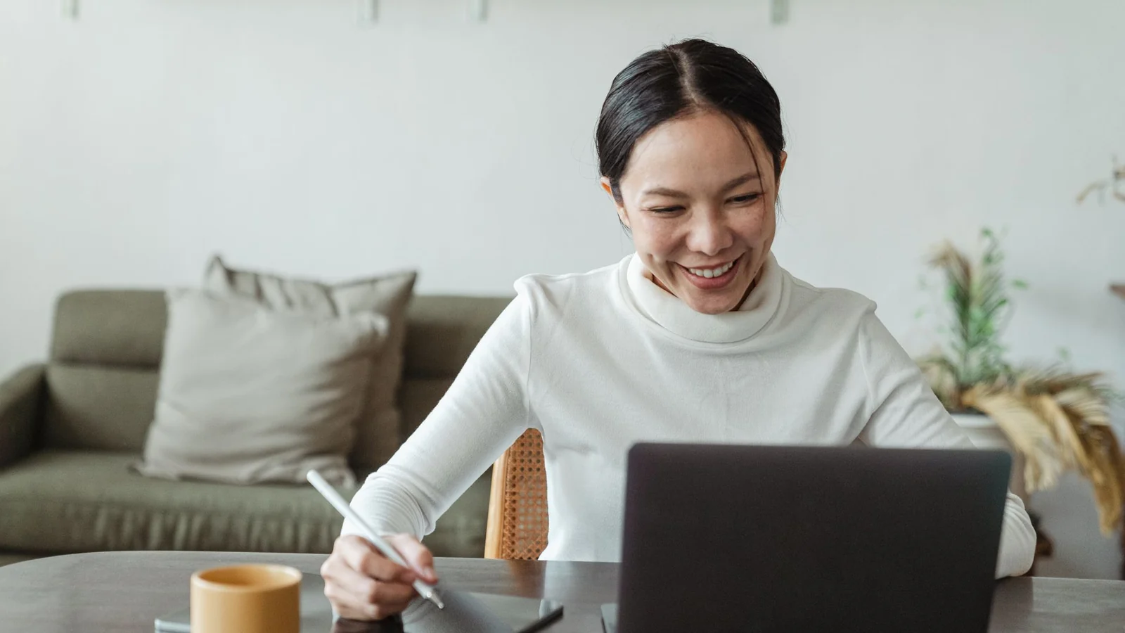 自宅でオンライン通話をしながら行動計画を進める女性