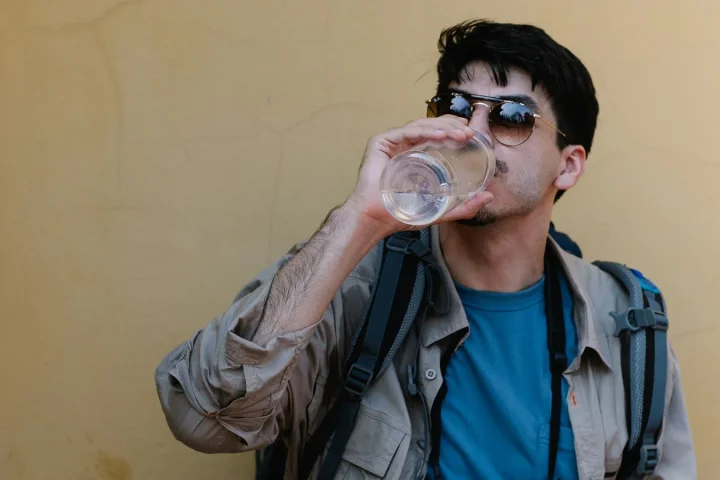 旅行中にボトル入りの水を飲む観光客