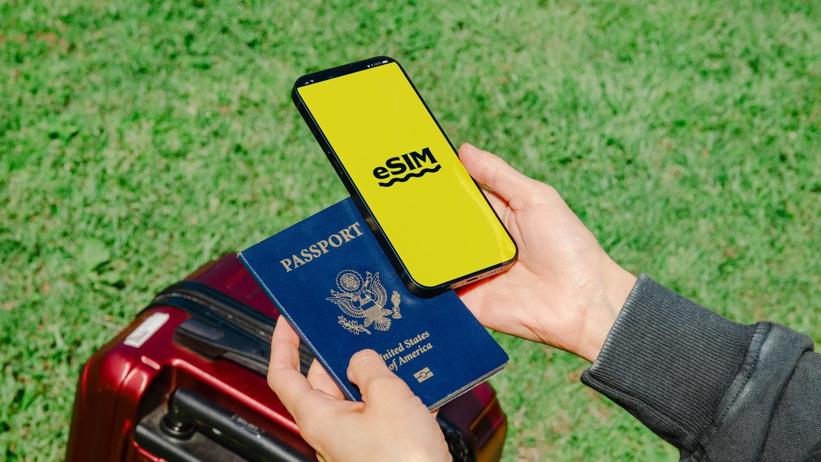 パスポートと荷物のそばでeSIM画面を確認する旅行者