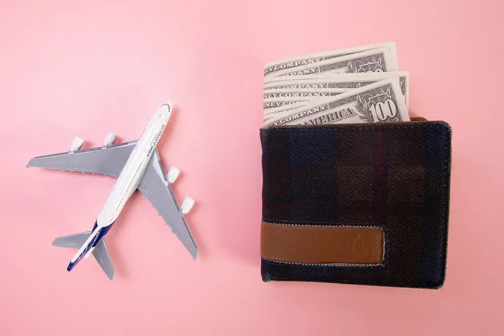 旅行予算を考えるWalletと小型Airplaneの模型