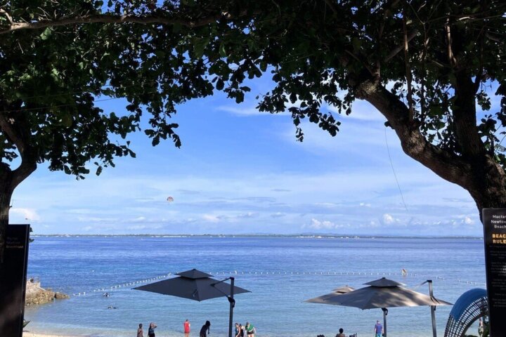 木陰から見たMactan Newtown Beachと海辺で過ごす人たち
