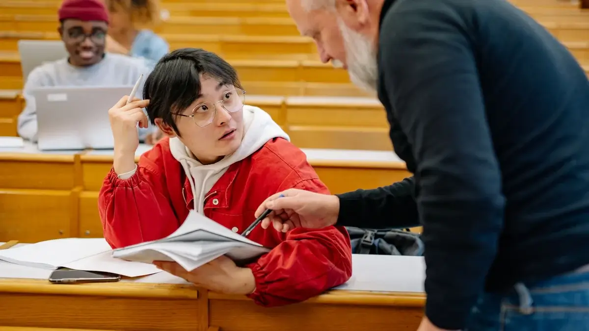教室で一対一に話す講師と学生