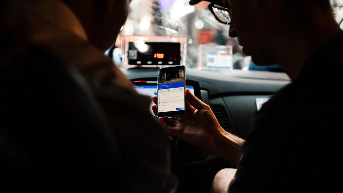 車内でスマートフォンを確認する人物(一般写真)