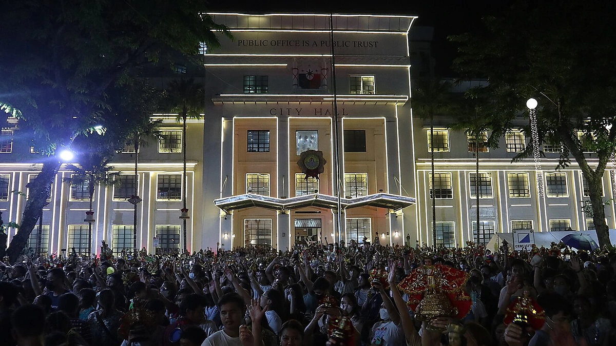 夜にライトアップされた建物の前に集まる人々