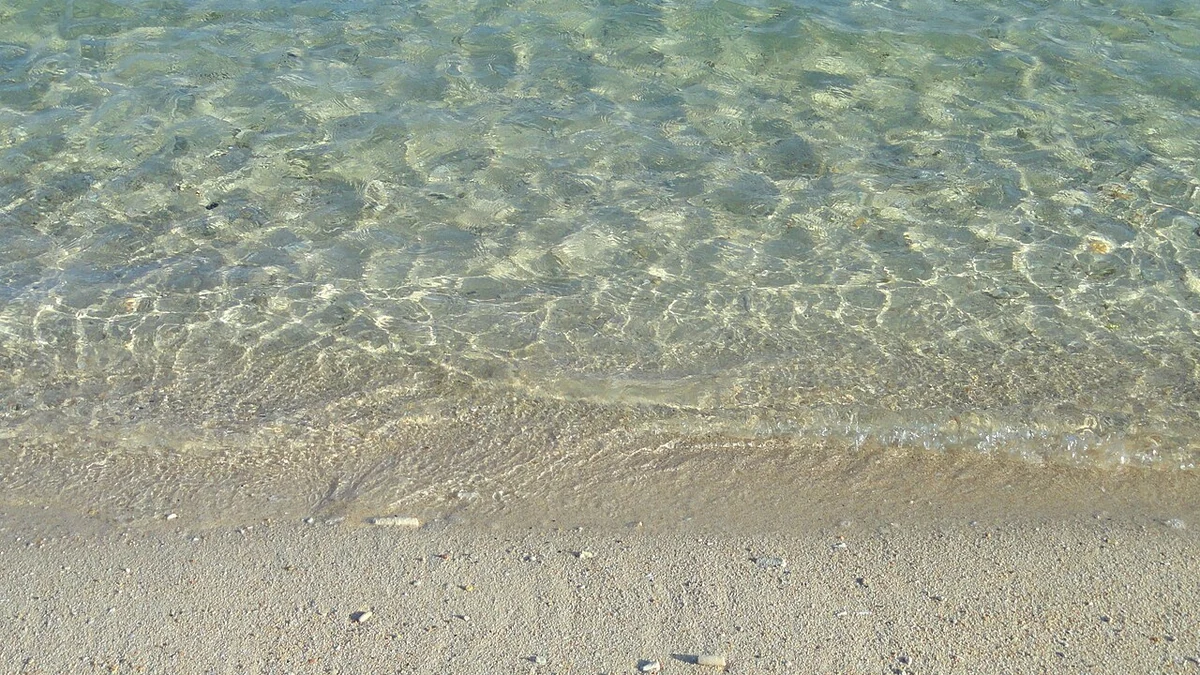 グアムの浅瀬に広がる透明な海水と砂