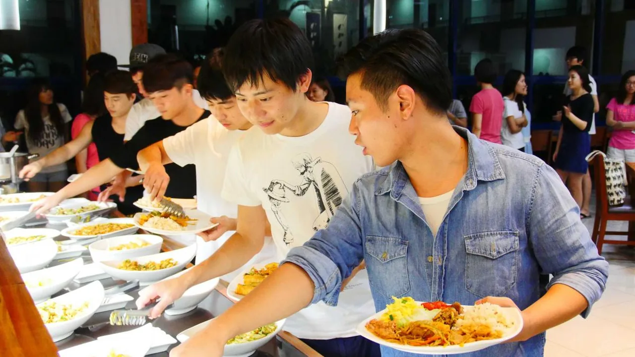 ビュッフェ形式の食堂で料理を取る学生たち