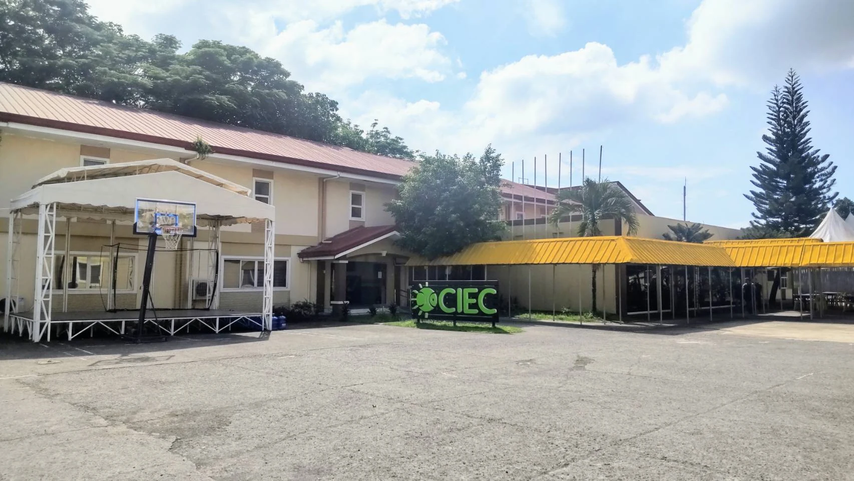 CIECの看板がある校舎と、バスケットゴールのある広い中庭