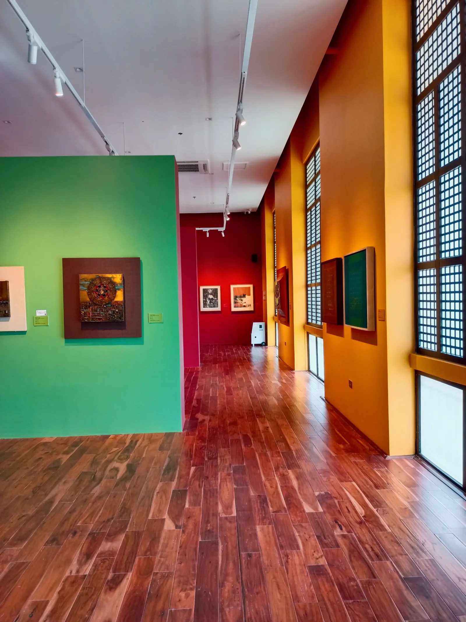 色の違う壁に絵画が掛かる2階の展示室