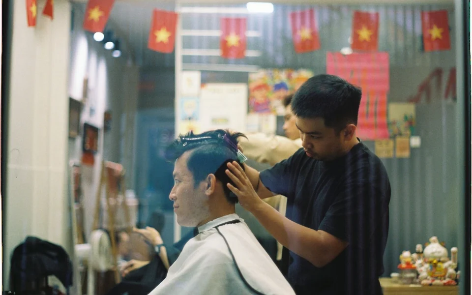 越南理发店内为顾客剪发的理发师