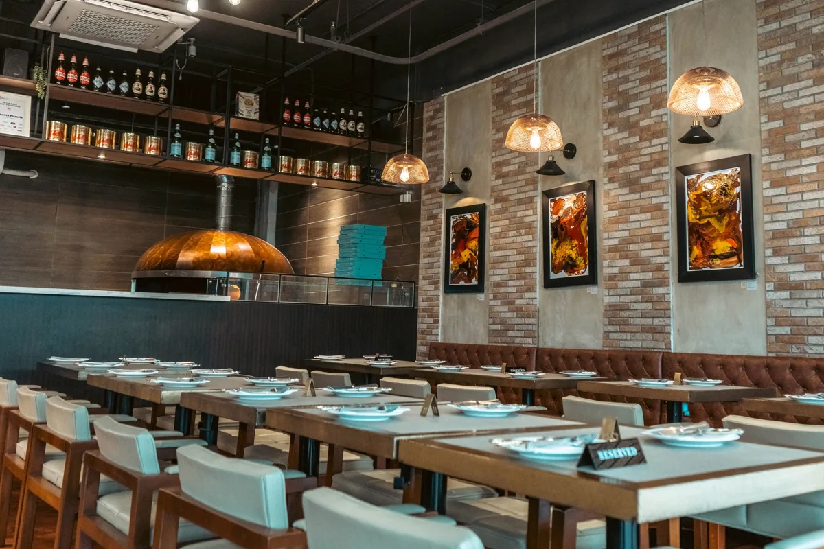 Pizzeria Playa的88th Avenue店内，餐桌前方可见披萨烤炉