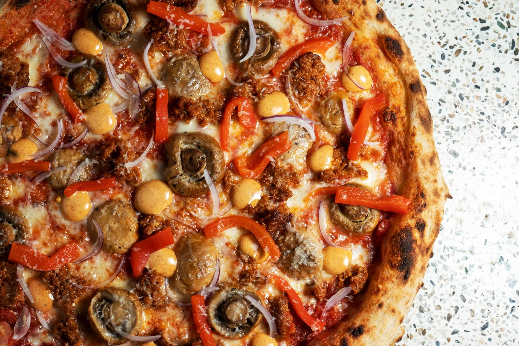 Pizzeria Playa披萨，上面铺有彩椒、洋葱和橄榄等配料