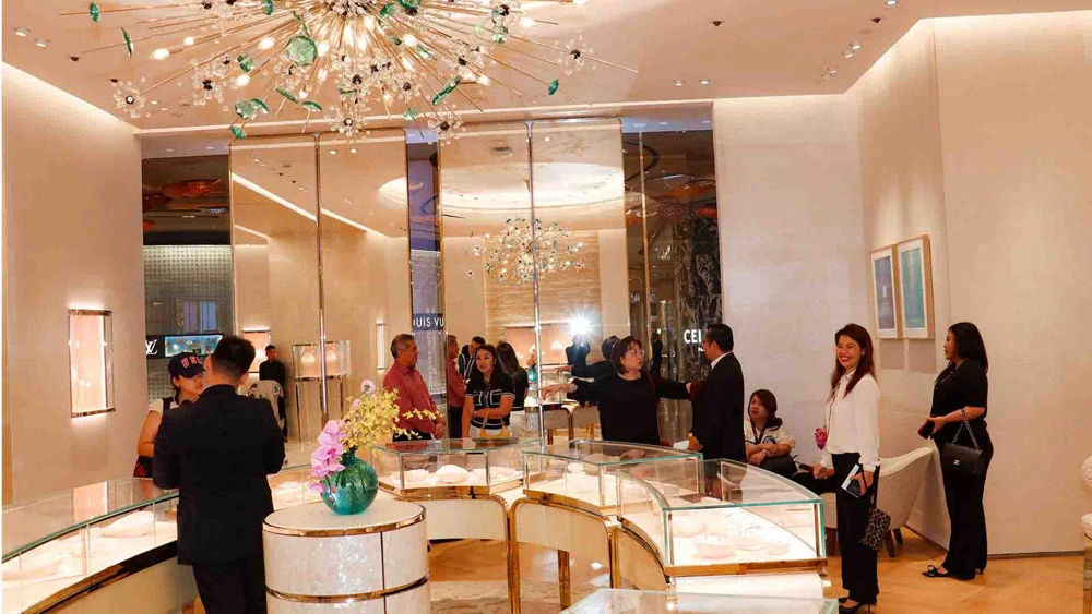 顾客在NUSTAR珠宝店展示柜前比较商品并接受咨询