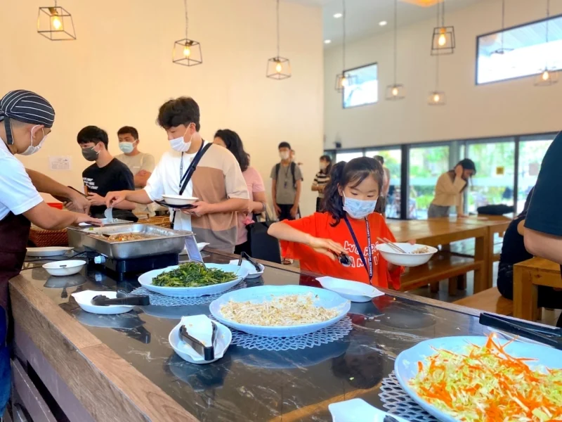 I.BREEZE学生在自助餐台排队盛取蔬菜和热食