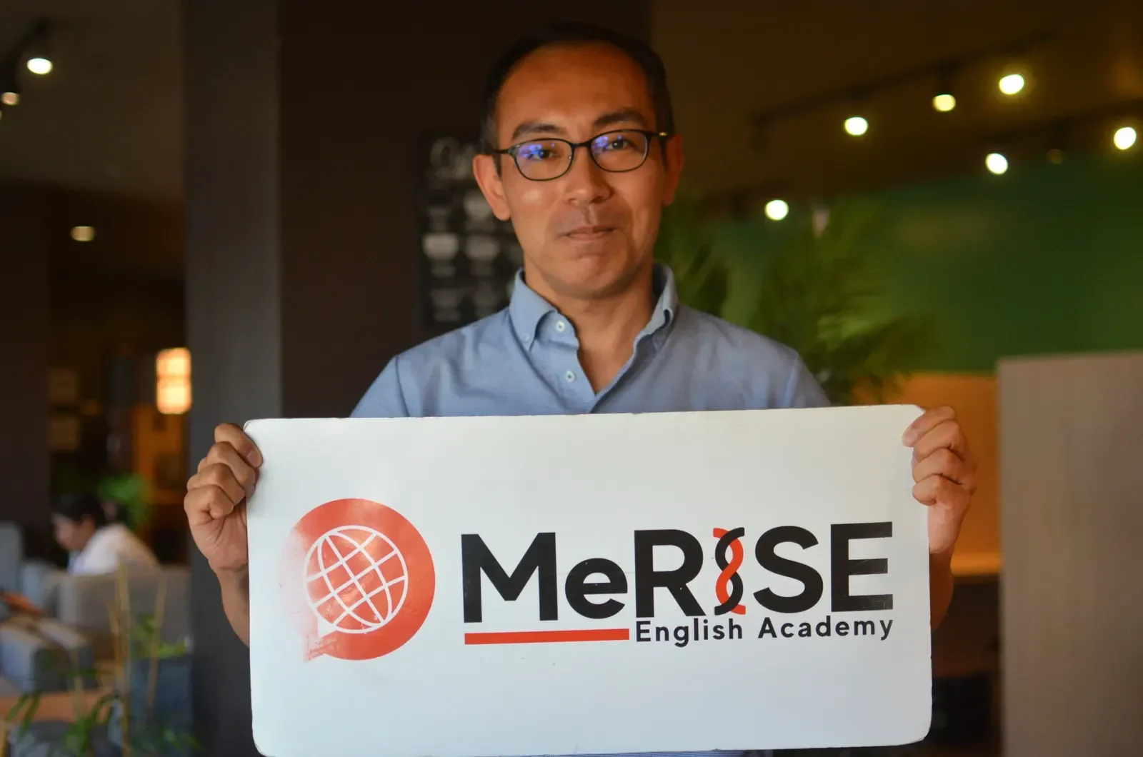 MeRISE工作人员手持学校标识