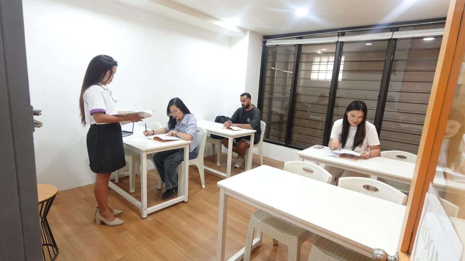 ICL English Academy小组课堂中教师巡视学生作业