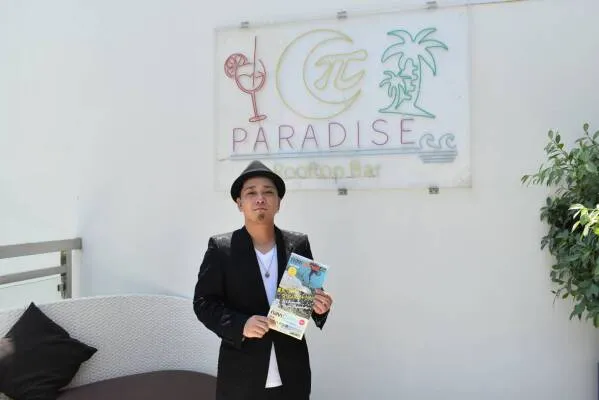 π PARADISEの看板の前に立つSHOGOさん