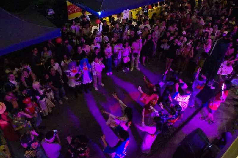 夜の会場で盆踊りをする人たち