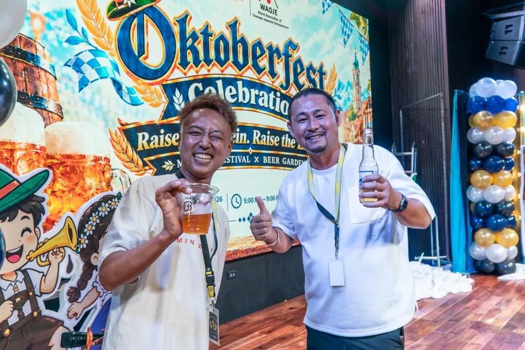 オクトーバーフェストの看板の前に立つ参加者